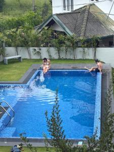 una pareja de personas sentadas en una piscina en Kandy Krush Hostel, en Kandy