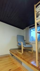 Ein Stuhl steht auf einem Holzpodest in einem Zimmer mit Fenster in der Unterkunft Waterfront Residence in Ladziņas + 18 Fotos