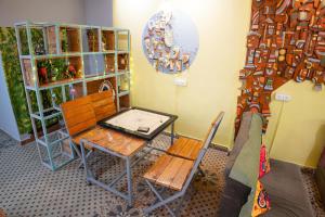 リシケーシュにあるTrippme Rishikesh, formerly The Swevenのテーブル、椅子、鏡が備わる客室です。