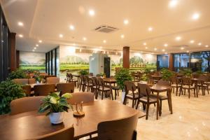 a restaurant with tables and chairs in a room at The Green Hotel Vientiane in Vientiane