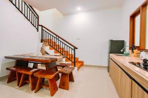 Una cocina con una mesa de madera y algunas sillas. en Nice Villa In Seminyak #YoNa, en Seminyak
