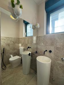 a bathroom with two sinks and a toilet at Maison Cesare in Ravenna +13 photos