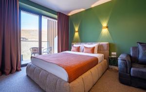 a bedroom with a bed and a large window at New Gudauri Apartments in Atrium in Gudauri