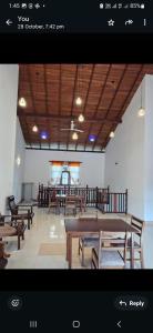 a restaurant with wooden tables and benches in a room at Royal Villa Polhena in Matara