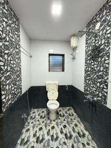 ein Badezimmer mit Toilette und Fenster in der Unterkunft Shinde Guest House in Kashid + 10 Fotos