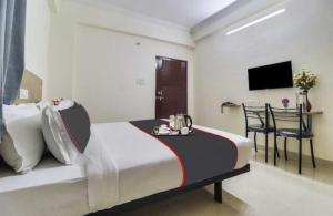 a bedroom with a bed with a tray of food on it at Super Collection O Rio Kondapur Near Rahavendra Colony in Hyderabad +34 photos