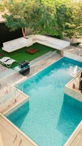 a large swimming pool with a table and a bench at Hummingbird Rak in Ras al Khaimah +67 photos