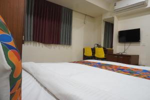 una habitación de hotel con cama y televisor de pantalla plana en Executive Residency, en Pune