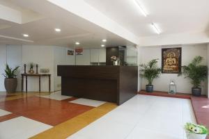 Un vestíbulo con mostrador de recepción en un edificio. en Executive Residency, en Pune