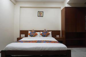 un dormitorio con una cama con sábanas y almohadas blancas en Executive Residency, en Pune 21 fotos más