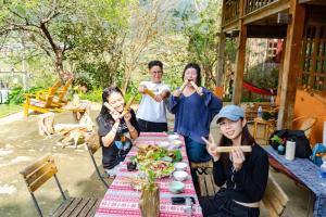 a group of people standing around a table with chopsticks at Casa De Dobby in Sa Pa
