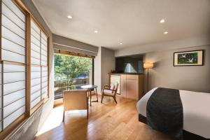 a bedroom with a bed and a table and a kitchen at Hakone Hibarino hot spring hotel in Hakone