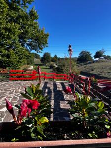 a park with a red fence and some plants and flowers at FreeMood Campaegli in Campaegli