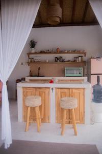 eine Küche mit einer Theke und 2 Hockern in der Unterkunft Villa Nyantara in Gili Air + 61 Fotos