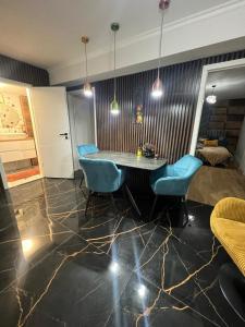 a living room with a table and blue chairs at GZP Residence Lugoj 16 in Lugoj