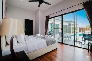 1 Schlafzimmer mit einem Bett und einem Balkon mit einem Pool in der Unterkunft Modern pool villa nature and beach Pak Nam Pran - hua hin in Ban Nong Sua