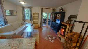 a living room with a white couch and a fireplace at Rogla Apartma Kekec in Zreče