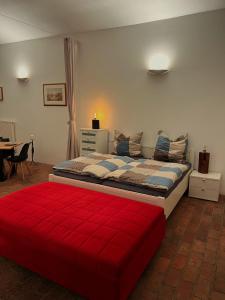 a bedroom with a large bed with a red blanket at Gewölbekammer Lichtenwalde in Niederwiesa