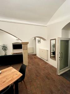 a living room with a wooden table and a wooden floor at Gewölbekammer Lichtenwalde in Niederwiesa