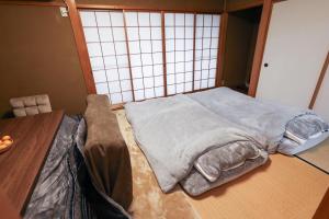 una cama grande en una habitación con una mesa en 1日1組限定の貸切の民泊です 全館禁煙です 屋外喫煙所無し 間取りは2LDkです 2階部分だけを貸し出してます 1階は立ち入りできません 翌年の3月31日までコタツを設置しています, en Fukui