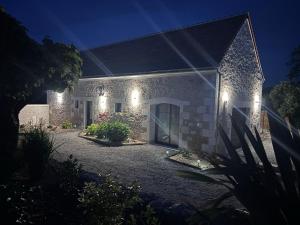 a stone house with lights on it at night at Gîte La Marnière in Luzillé