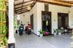 two scooters parked outside of a house at cozy haven in Midigama