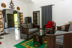 a living room with a red teddy bear sitting on chairs at cozy haven in Midigama