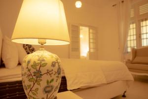 a lamp sitting on a table next to a bed at Evergreen Hideout by Tequila Holidays in Kandangama