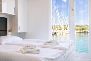 a bedroom with a bed with white towels on it at Lovely HouseBoat Apartment Portorose in Portorož +17 photos