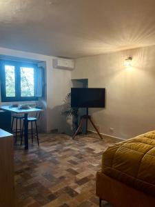 ein Wohnzimmer mit einem Bett und einem Tisch und einem Fernseher in der Unterkunft Dimidia - casa vacanze mare montagna in Capaci