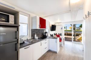 a kitchen with white cabinets and a sink at Lovely HouseBoat Apartment Portorose in Portorož