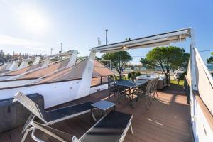 a deck with a table and chairs and a boat at Lovely HouseBoat Apartment Portorose in Portorož