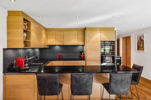 a kitchen with a black counter top and wooden cabinets at Charming Apartment in Gsteig in Gsteig