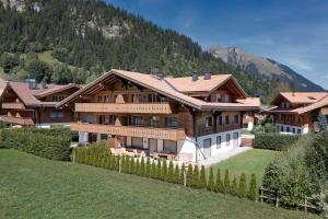 a large wooden house with a mountain in the background at Charming Apartment in Gsteig in Gsteig