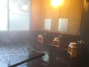 雾岛市～みらい荘～　天然温泉付き一日一組様限定の６４坪広々民泊別荘的浴室里有一个水池和三个凳子