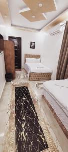 a room with two beds and a rug on the floor at pyramids dreams in Cairo