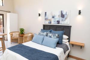 a bedroom with a bed with blue pillows at Studio 51 in Port Alfred