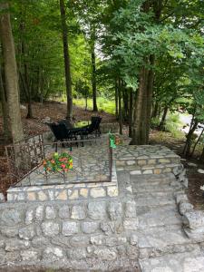 a patio with two chairs and a table and flowers at Vikendica Silenzio in Cetinje