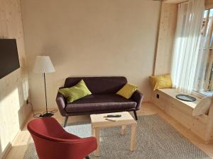 a living room with a couch and a table at StrohGlück Rigi - traumhafte nachhaltige Ferienwohnungen mit toller Aussicht in Rigi Kaltbad