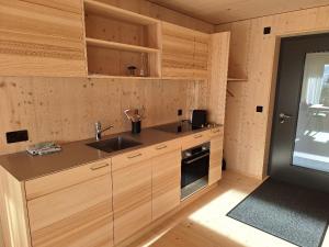 a kitchen with wooden cabinets and a sink at StrohGlück Rigi - traumhafte nachhaltige Ferienwohnungen mit toller Aussicht in Rigi Kaltbad +8 photos