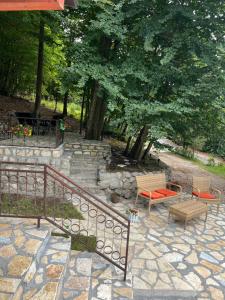 a patio with two chairs and a bench and stairs at Vikendica Silenzio in Cetinje