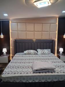 Un dormitorio con una cama grande con un cabecero grande. en Omnia Luxe Villa, en Pānigata