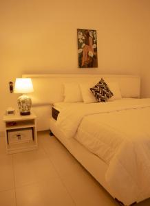 a bedroom with a bed and a table with a lamp at Evergreen Hideout by Tequila Holidays in Kandangama