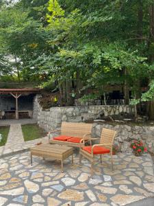 two chairs and a bench on a stone patio at Vikendica Silenzio in Cetinje