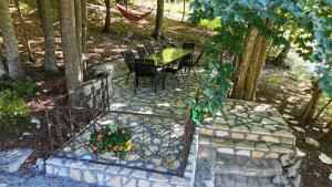 a patio with a table and chairs in the woods at Vikendica Silenzio in Cetinje