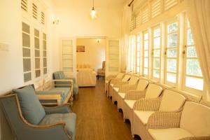 a waiting room with rows of chairs and windows at Evergreen Hideout by Tequila Holidays in Kandangama