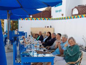 a group of people sitting at a long table at Nubian Spirit in Aswân Reservoir Colony +43 photos