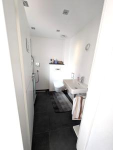 ein weißes Badezimmer mit Waschbecken und Toilette in der Unterkunft Modern habitable gallery, centrally located in Hirschaid in Hirschaid + 10 Fotos