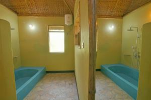 a bathroom with two blue tubs and a window at Enshama Game Lodge and Campsite in Katunguru