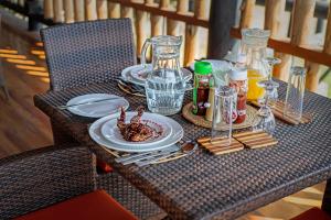 a table with plates of food and glasses on it at Enshama Game Lodge and Campsite in Katunguru +37 photos